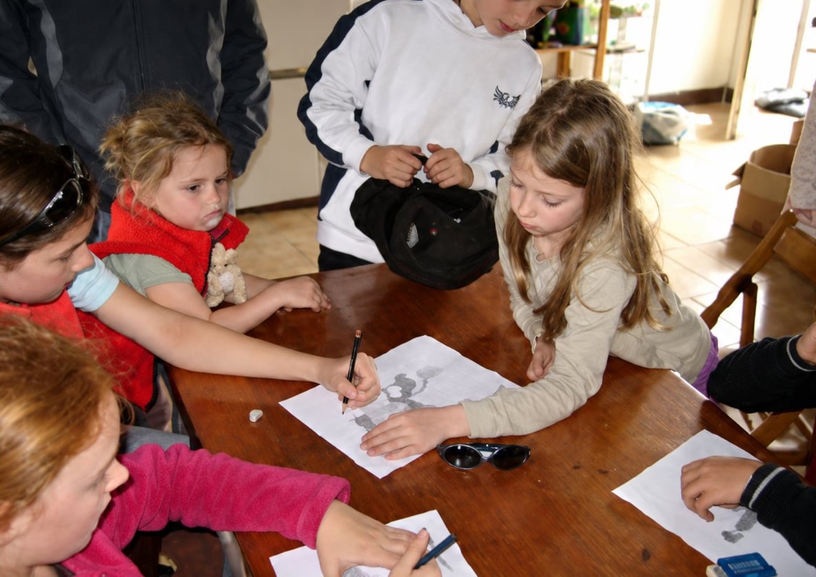 Enfants dessinant autour d’une table lors d’un atelier