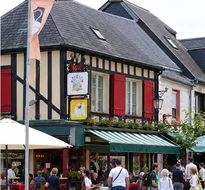 Façade d’un bâtiment à colombages avec volets rouges et terrasse